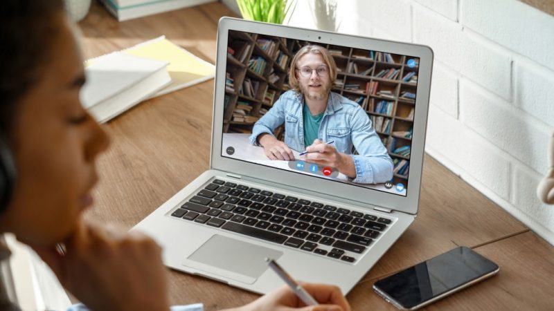 African teen girl college student, school pupil wears headphones distance learning from home on video conference call, web cam chat with online teacher tutor remote lesson on computer screen, closeup.